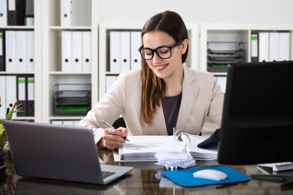 Smiling young female employee working on accounting tasks
